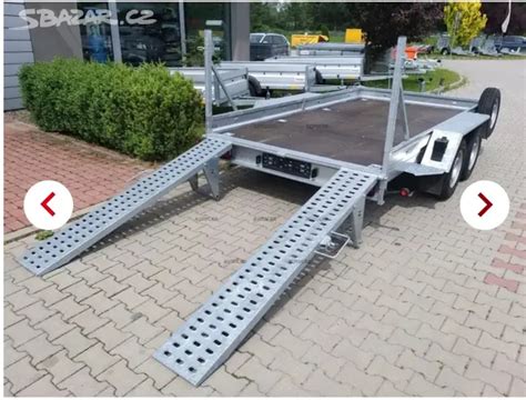 Boční pohled na přívěsný vozík s koly umístěnými vedle ložné plochy