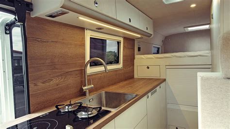 Interiér obytné vestavby Fiat Ducato s kuchyňkou a spací zónou