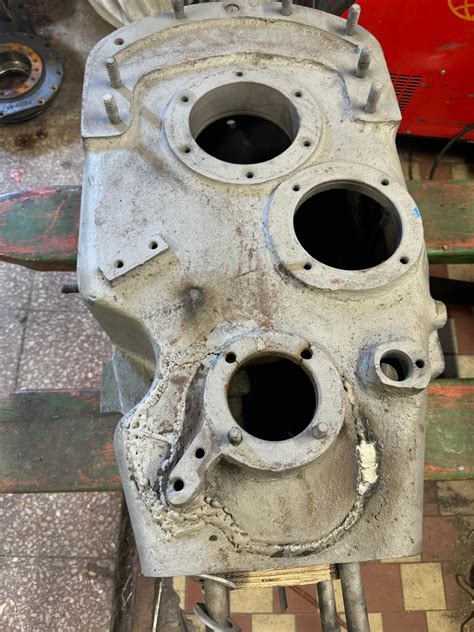 Detail kostřícího pásku připevněného k bloku motoru