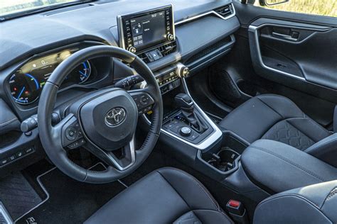 Detail interiéru Toyoty RAV4 s ergonomicky uspořádanými ovladači a oranžovým prošíváním