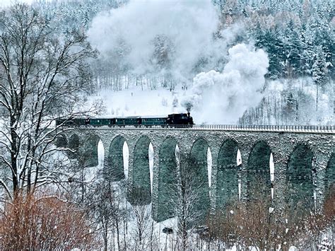 Fotografie vlaku na viaduktu v malebné krajině