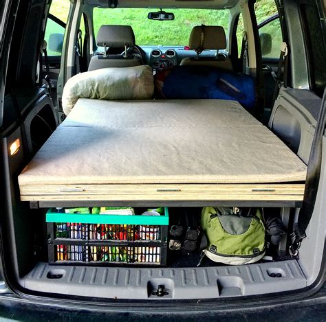 Detailní pohled na rozloženou vestavbu pro spaní v autě s vyobrazením matrace a úložného prostoru.