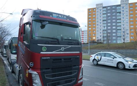 Ilustrace znázorňující přeplněné parkoviště pro kamiony s řadou stojících vozidel.