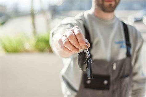 Pracovník autobazaru předává klíče novému majiteli vozu