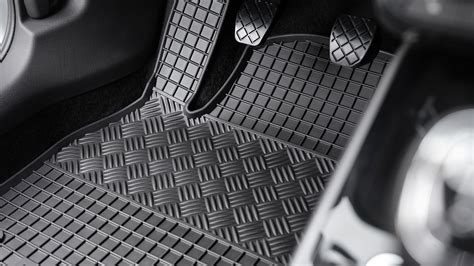 Detail gumového autokoberce Rigum s vyznačeným vysokým okrajem a protiskluzovou spodní stranou.