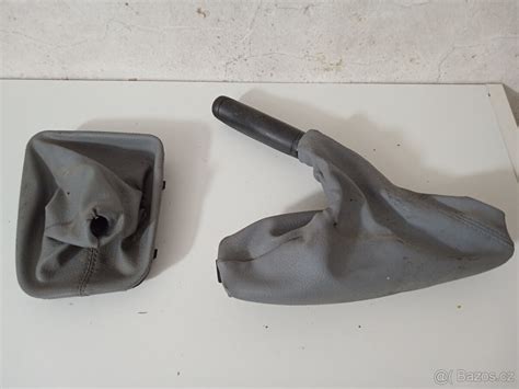 Demontovaný plastový tunel a stará manžeta ruční brzdy