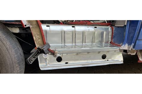 Detailní záběr na masivní plechy karoserie Mercedesu W123 s důrazem na kvalitu zpracování.