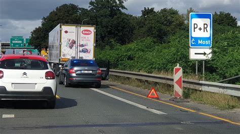 Ilustrace správného umístění výstražného trojúhelníku za stojícím vozidlem na krajnici.