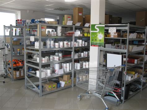 Interiér moderní prodejny náhradních dílů s regály plnými autodílů.