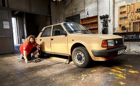 ilustrační foto dílny s mechanikem kontrolujícím auto