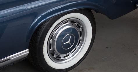 ilustrace pneumatiky s výrazným bílým nápisem na boku