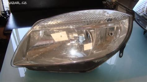 Detailní záběr na přední světlomet a masku chladiče vozu Škoda Fabia II