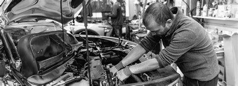 Ilustrační fotografie servisního centra s mechaniky pracujícími na automobilech