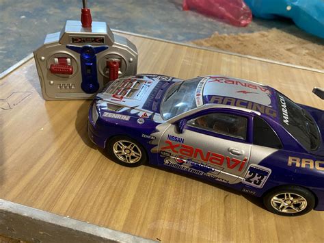 Detailní záběr na dálkové ovládání dětského autíčka a bezpečnostní pás.