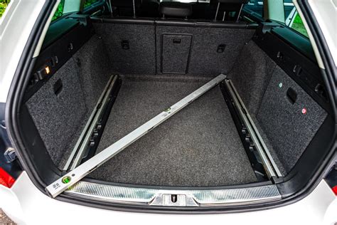 Ilustrace postupu demontáže zadního obložení kufru u Škoda Superb Combi s vyznačením zámečků.