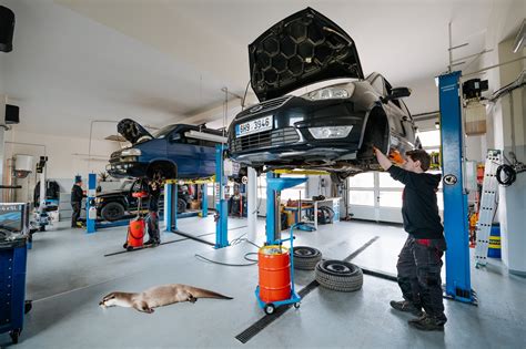 Ilustrační foto autoservisu s mechaniky pracujícími na vozidle