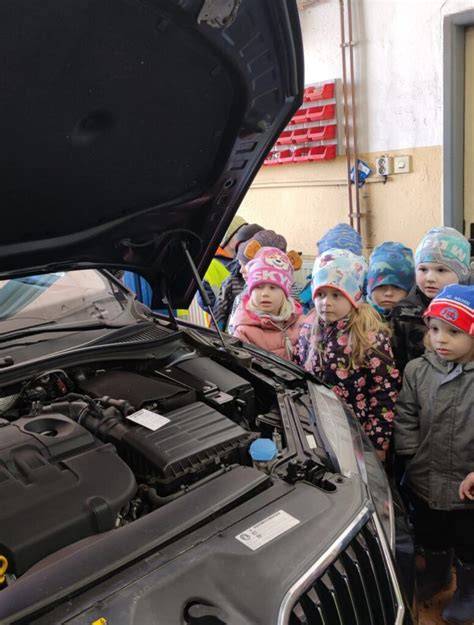 výuka v autoservisu, studenti u auta