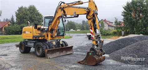Kolový bagr Volvo EWR135 v provozu.