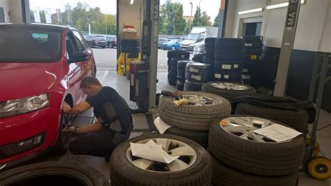 Ilustrační foto pneuservisu s mechanikem pracujícím na vozidle