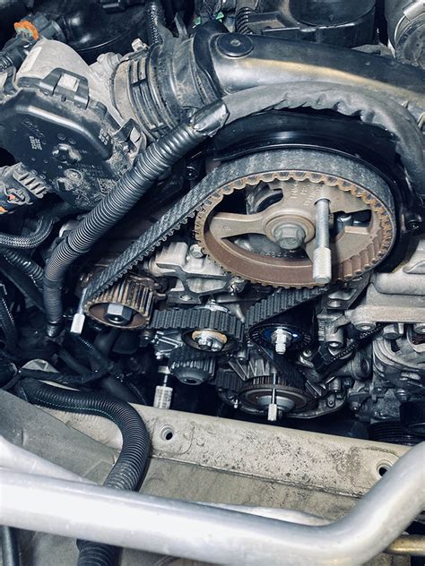 Detailní pohled na složení rozvodové sady, včetně řemene, kladek a vodní pumpy.