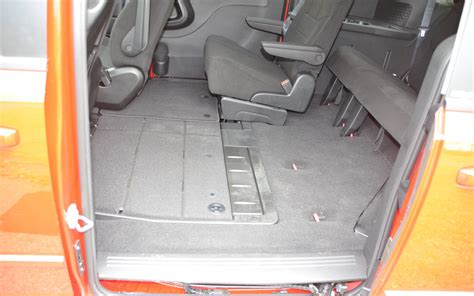 Detail interiéru Dodge Grand Caravan s vyobrazením variability sedadel a odkládacích prostor.
