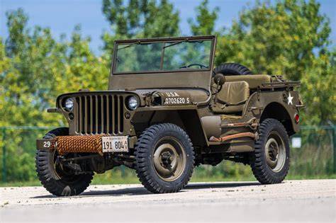 Foto historického Willys MB 1941-1945 s otevřenou kabinou a typickým plátěným pláštěm.