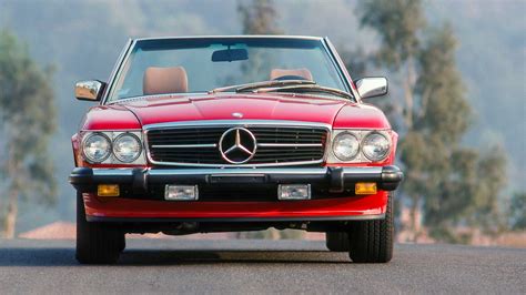Detail přední části vozu Mercedes-Benz R107 s chromovanou maskou a světlomety